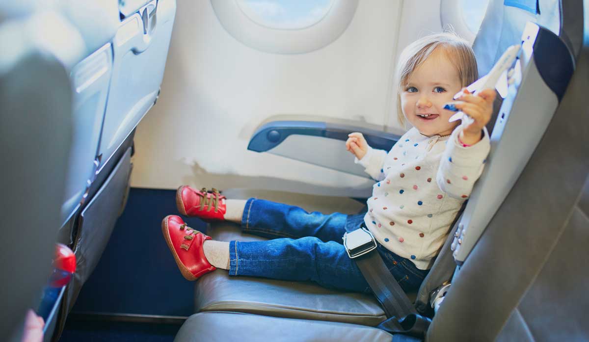 A toddler holding an airplane toy during their family's flight