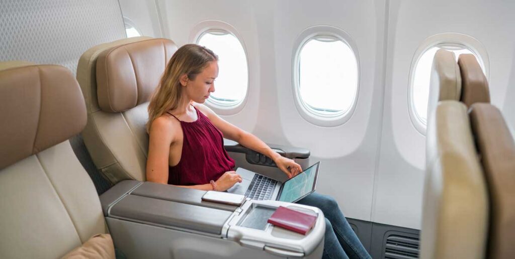 A woman working on her laptop during a flight