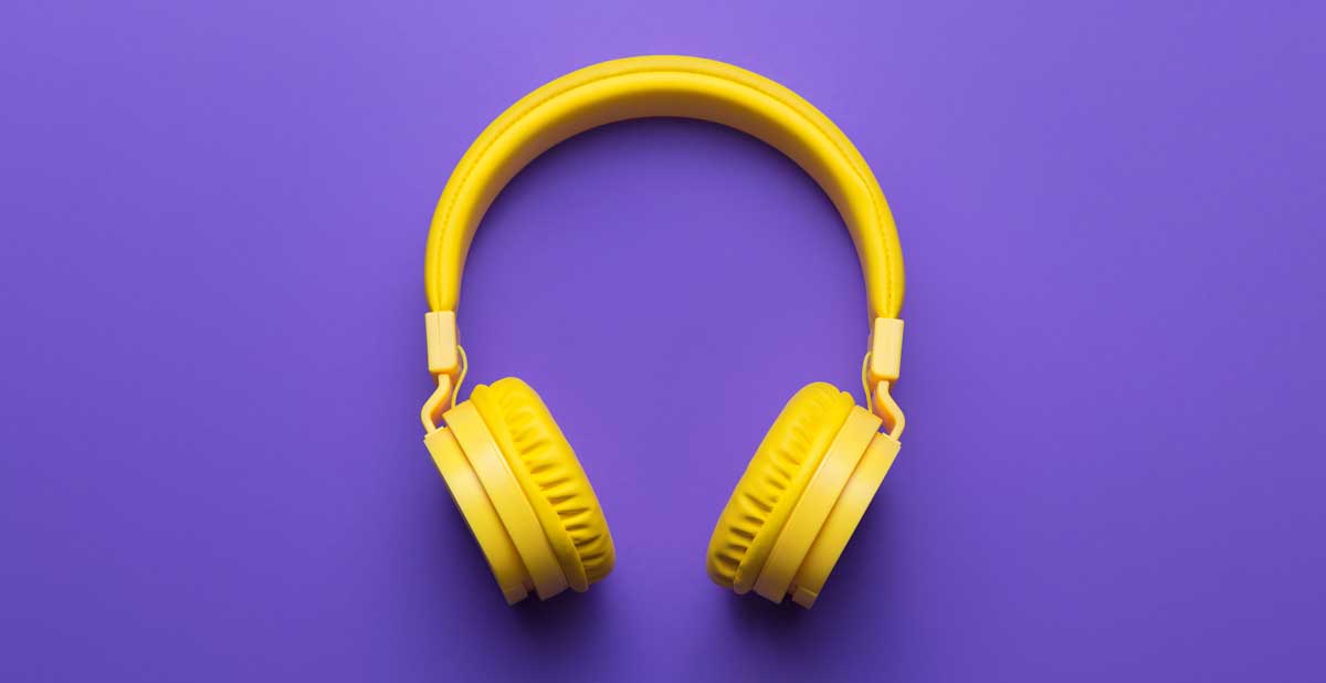 A yellow wireless headphones on a purple background