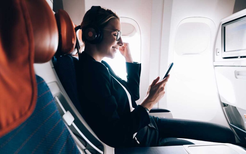 A woman looking at her phone during a flight