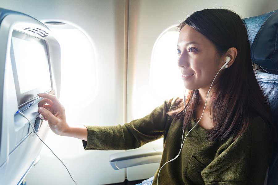 A woman picking a movie during her flight
