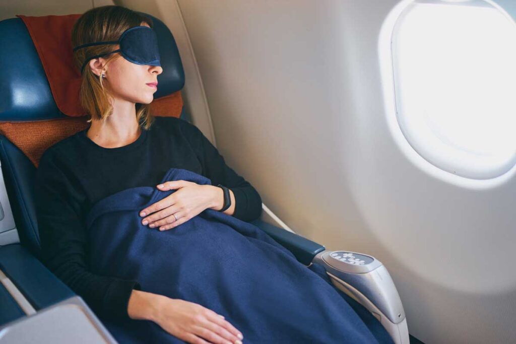 A woman sleeping on a plane during her flight