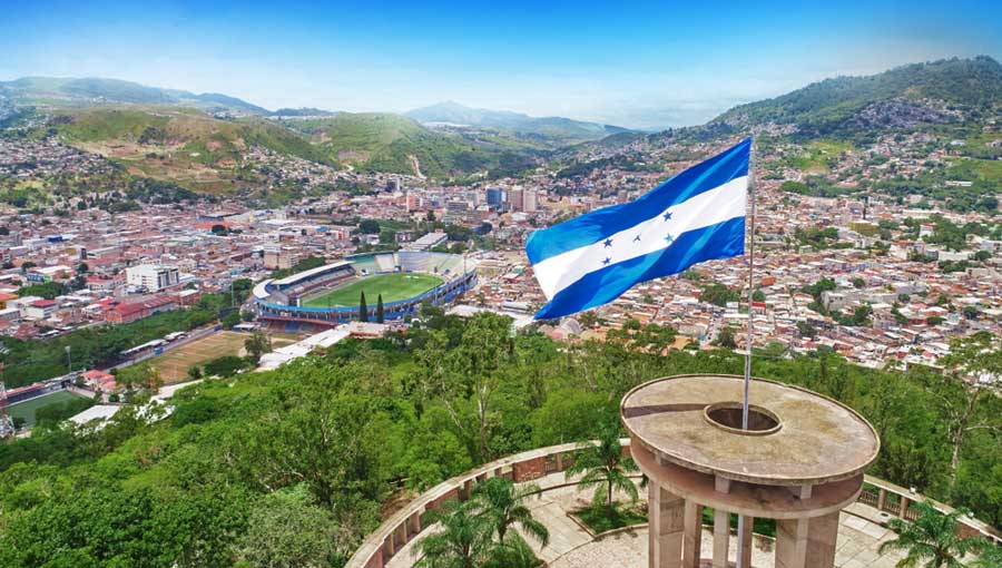 The flag of Honduras and an overlooking view of the Tegucigalpa