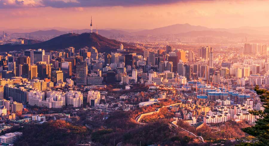 Aerial view of buildings in Seoul during sunset, one of the cheapest places to fly abroad from the USA